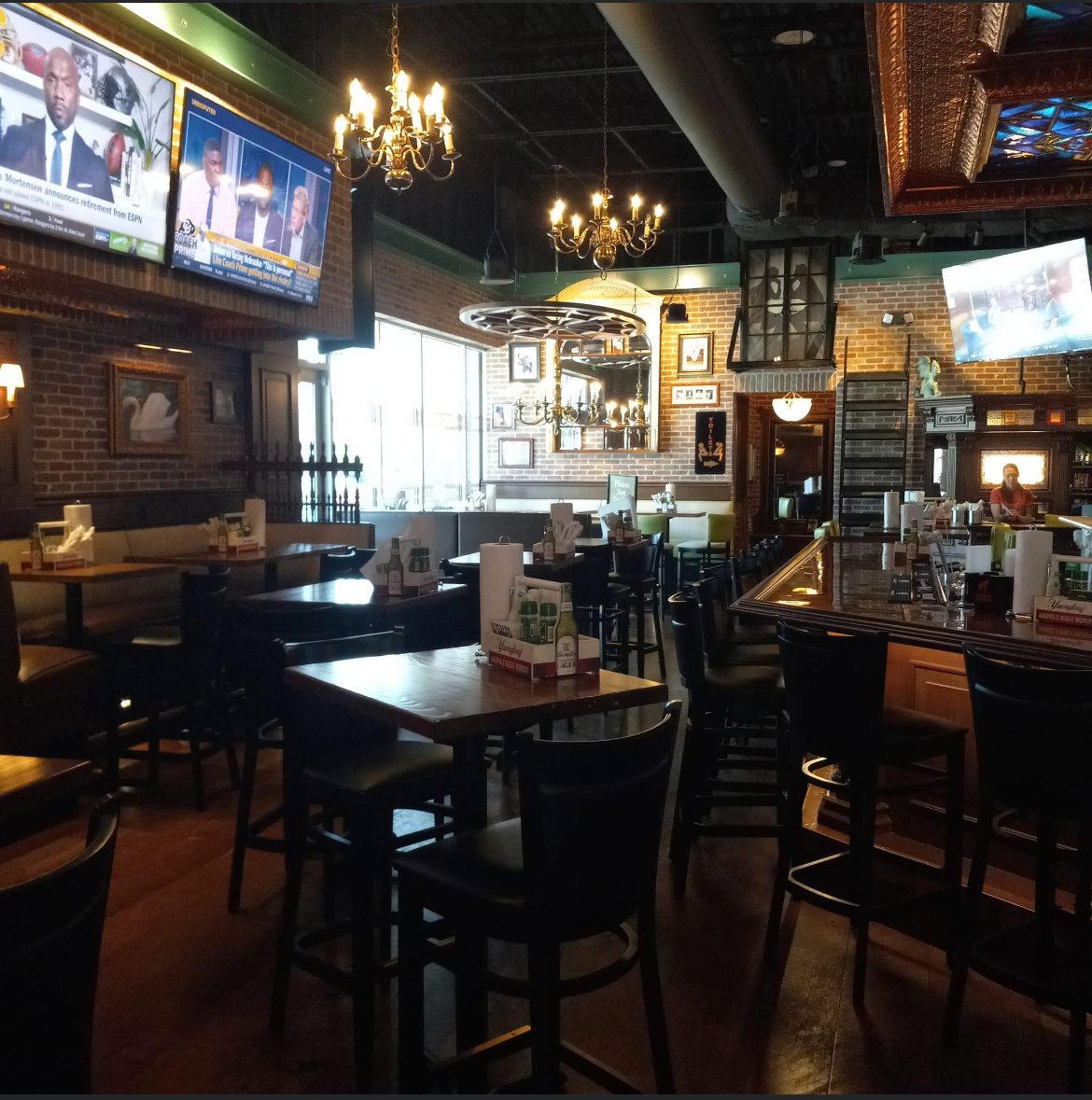 Restaurant and bar interior with chandeliers, wall sconces and mounted televisions
