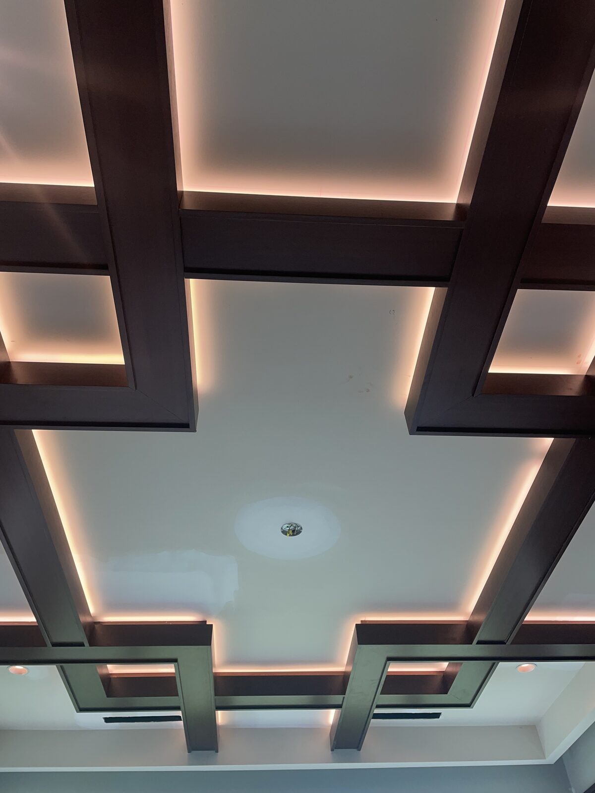 Coffered wood ceiling with warm cove lighting behind the beams
