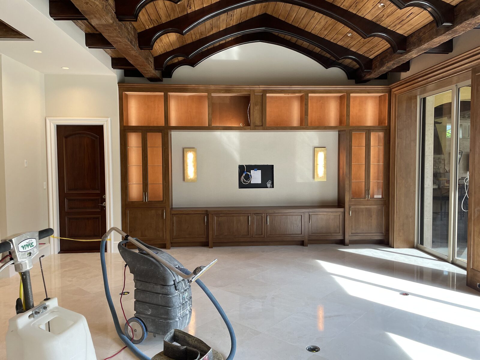 Built-in media wall with lit display cabinets and wall sconces