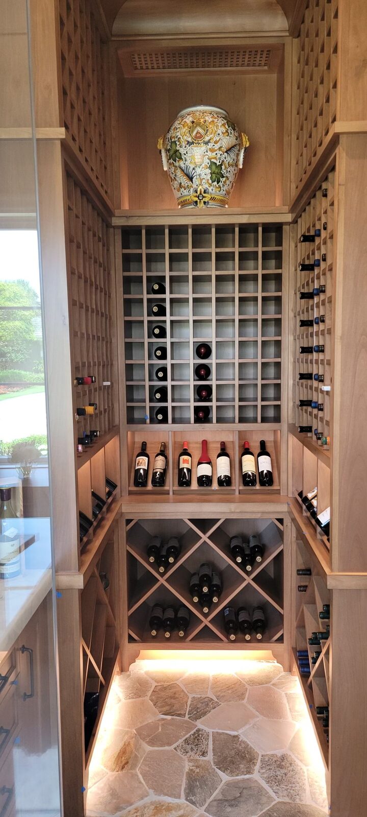 Wine room with wood racking and lighting washing the stone floor