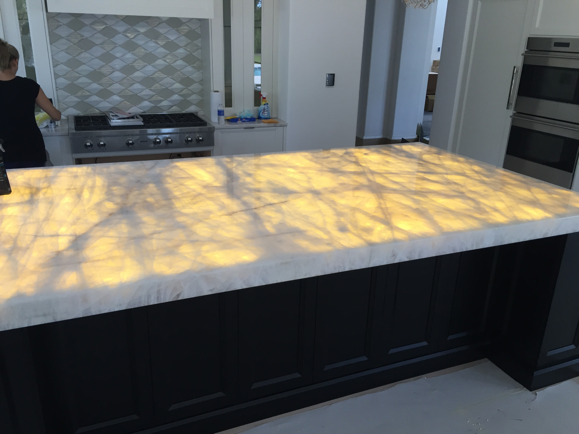 Backlit quartzite kitchen island glowing from LED lighting installed beneath the stone