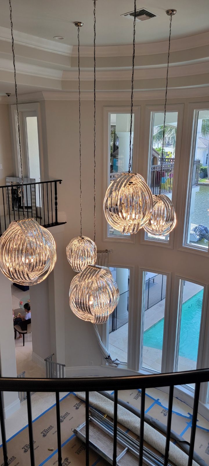 Cluster of glass globe pendant lights hung in a two-story stairwell