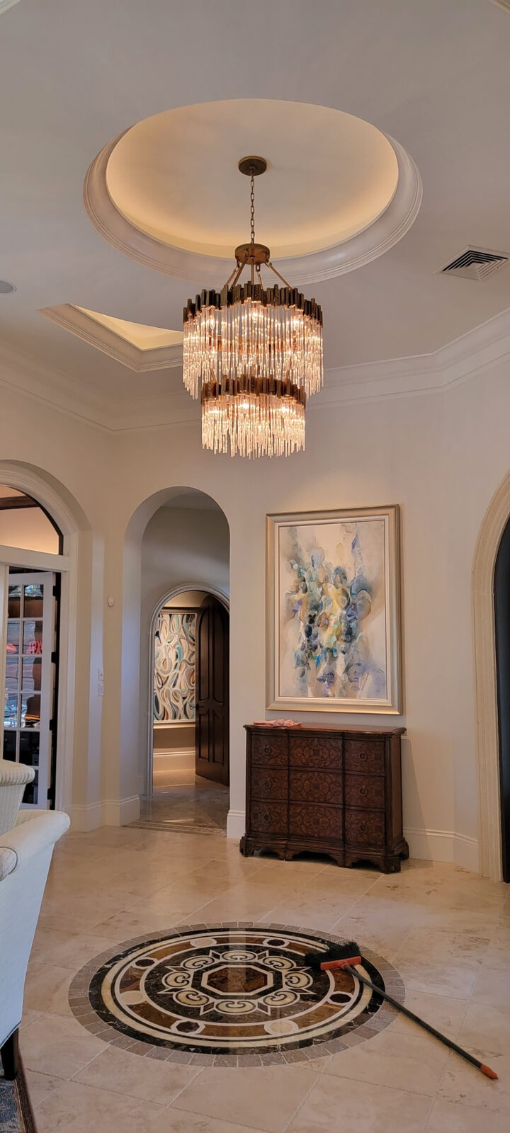 Modern glass rod chandelier centered in a round tray ceiling in a home entry