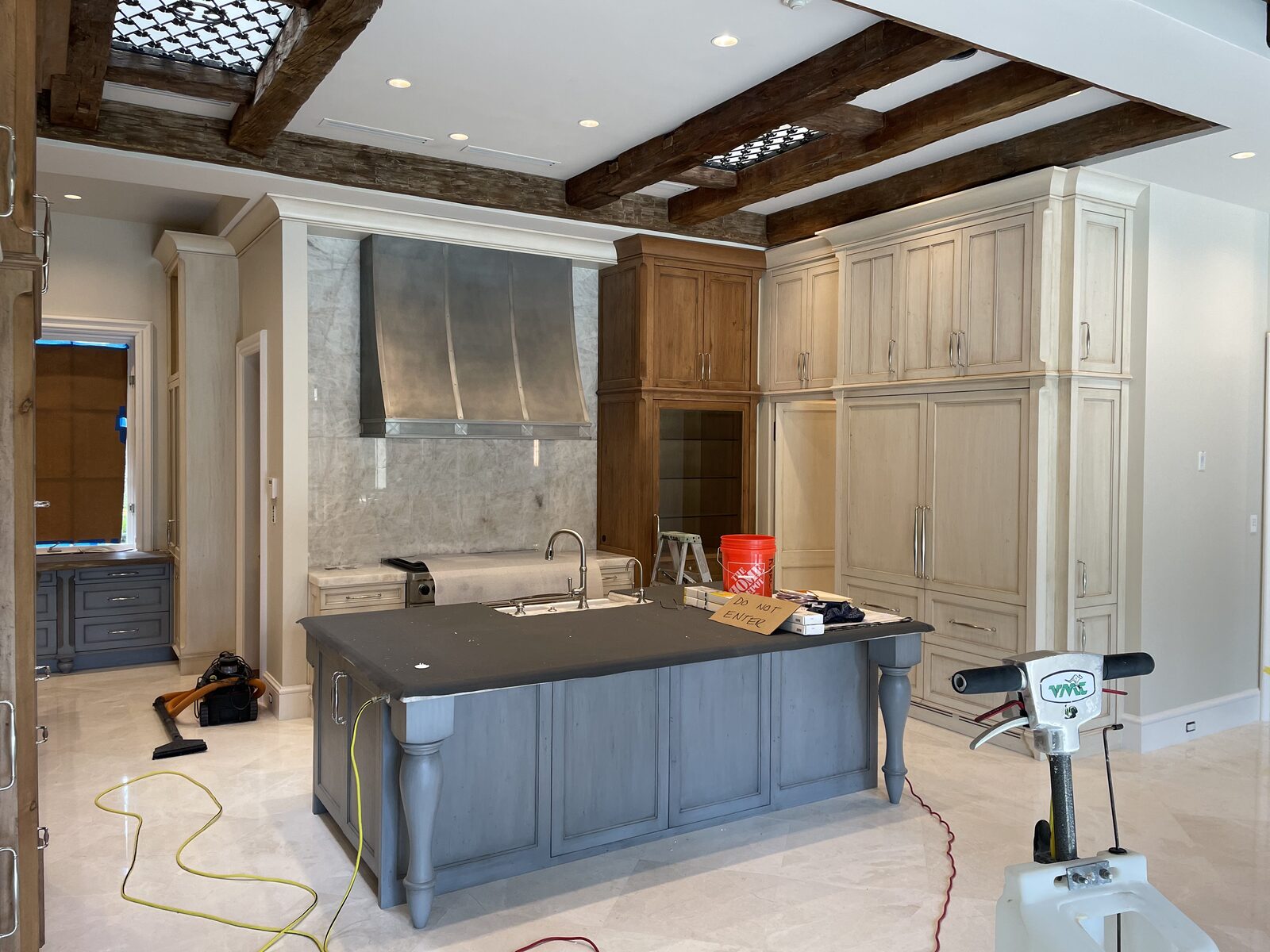 Kitchen with recessed ceiling lights, beams and a large island under construction