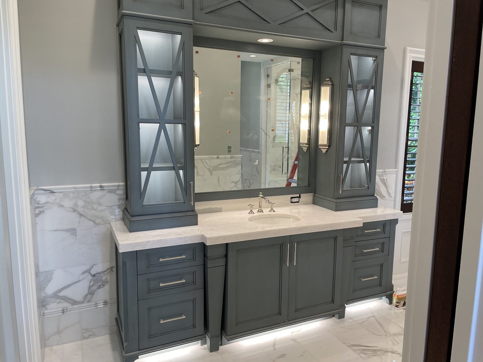 Bathroom vanity with mirror sconces, lit cabinets and under-cabinet lighting